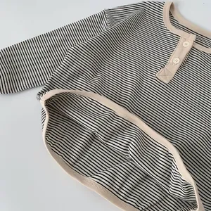 Detail of boys striped cotton long sleeve tee featuring a classic henley neck with white buttons