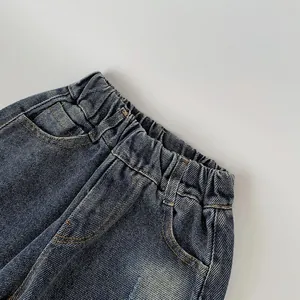 Detail of elastic waistband on dark blue denim pants with high-quality stitching