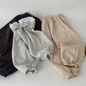 Vue à plat de pantalons de jogging pour enfants avec broderie et taille élastiquée