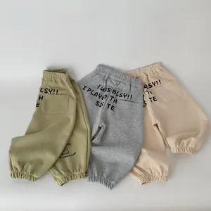 Dettaglio di pantaloni joggers in cotone con vita elastica e stampa artistica naturale