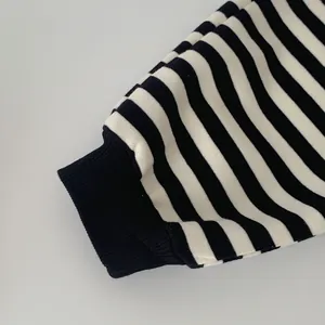 Close-up of black and white striped knit cuff with black ribbed elastic design detail