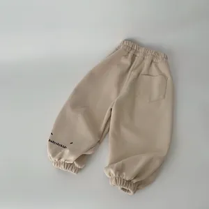 Détail du jogging enfant avec taille élastique et broderie sur le bas du pantalon