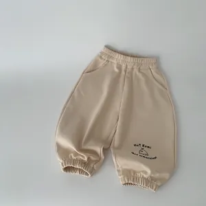 Pantaloni jogger beige in cotone per bambini con stampa Hot Kumi e polsini elastici