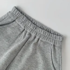 Dettaglio dei pantaloni sportivi grigio chiaro con vita elastica e cuciture rinforzate