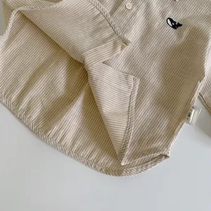 Detail of cotton-linen striped shirt for kids featuring a small dark whale embroidery
