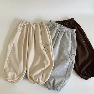 Détail de la broderie cartoon sur pantalon de jogging en coton pour enfant en trois coloris