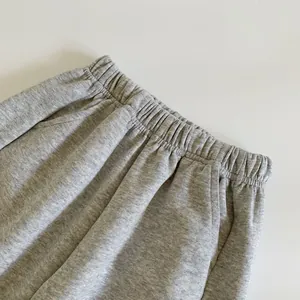 Détail du jogging gris pour enfant montrant la taille élastique et le tissu en maille