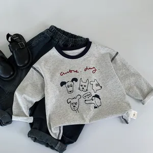 Detailed flat lay of children's grey long sleeve tee with dog prints and denim jeans