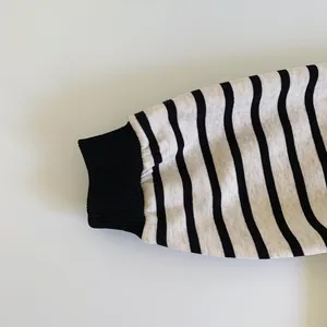 Detailed view of black and white striped cotton knit sleeve with ribbed cuff for kids