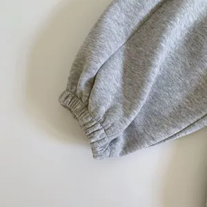 Vue macro des bords-côtes élastiques sur un pantalon de sport gris chiné en coton