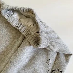 Détail du pantalon de sport gris pour enfant avec taille élastique et doublure en maille