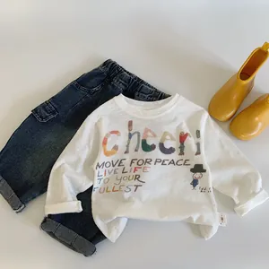 Flat lay of kids white long sleeve T-shirt with cartoon print and denim jeans