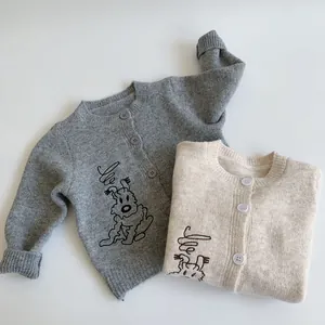 Close-up of soft knitted cardigans with exquisite puppy embroidery and button details