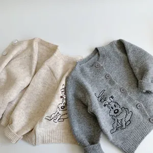 Detailed knit texture of beige and grey mohair cardigans with cartoon embroidery