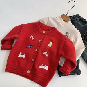 Dettaglio del cardigan rosso per bambini con ricami di cani e bottoni in legno