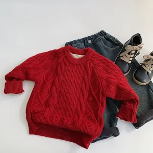 Flat lay of red cable knit sweater for kids paired with jeans and black shoes