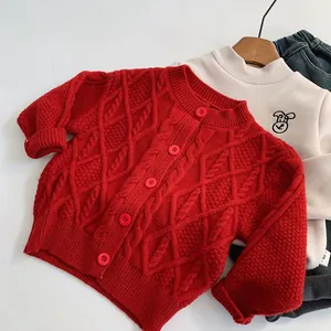 Détail du cardigan en tricot torsadé rouge avec boutons et poignets côtelés