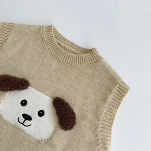 Gros plan sur un gilet en tricot beige avec un chiot mignon et oreilles douces