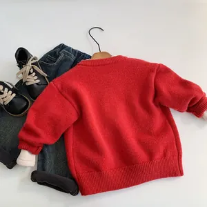 Maglione in maglia rossa con ricamo, abbinato a jeans e stivaletti per bambini