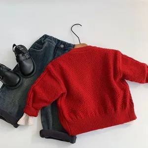 Pull en tricot rouge pour enfant avec jean bleu foncé et chaussures en cuir verni noir