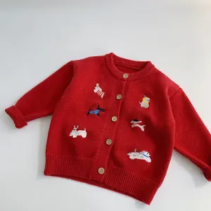 Dettaglio di cardigan rosso in maglia con ricami di cuccioli e bottoni in legno