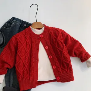 Détail du cardigan rouge pour enfants avec maille torsadée et boutons rouges assortis