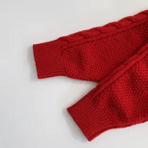 Détail du poignet en maille torsadée rouge avec texture côtelée épaisse pour l'hiver