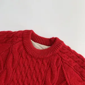 Detail of red cable-knit sweater showing thick ribbed crew neck and textured wool pattern