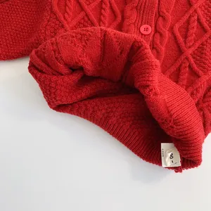 Cardigan tricoté rouge pour enfants avec motifs de torsades et détails de boutons