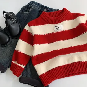 Dettaglio del maglione a righe rosse e bianche per bambini con polsini e collo a coste