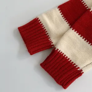 Dettaglio dei polsini in maglia a costine a righe rosse e bianche per maglioni bimbi