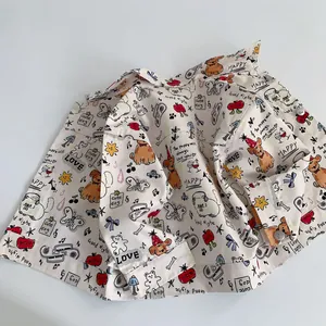 Detail of baby cotton shirt featuring colorful cartoon puppy and bear prints