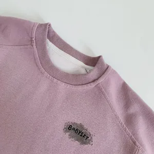 Close-up of ribbed crewneck and BABYSKY text on soft cotton kids sweatshirt