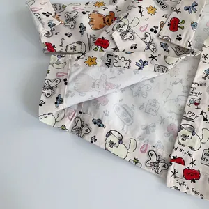 Toddler cream cotton shirt featuring colorful cartoon prints of dogs, apples, and stars