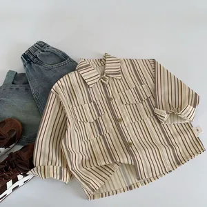 Gros plan d'une chemise rayée pour enfant avec poches poitrine et étiquette de taille 90