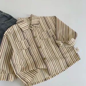 Détail d'une chemise rayée pour garçon avec poches poitrine et étiquette de taille 90