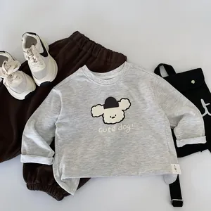 Détail à plat de l'ensemble sweat-shirt gris à dessin animé et pantalon marron