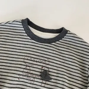 Détail d'un sweat-shirt à rayures pour garçon avec motif dessin animé rouge et col rond
