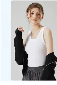 Detailed texture of white ribbed cotton tank top paired with a zip-up knit cardigan
