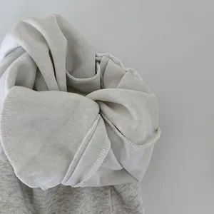 Dettaglio ravvicinato del morbido cotone spugna bianco e cuciture di qualità sul polsino