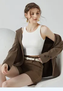 Détail d'un débardeur court blanc côtelé avec un blazer beige et un short assorti