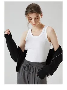 Detail of white ribbed tank top layered with a black knit zip-up hoodie and grey joggers