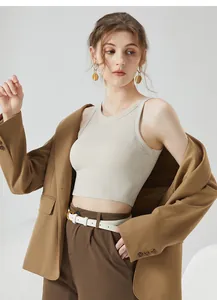 Détail d'un débardeur beige côtelé court porté avec un blazer marron et des boucles
