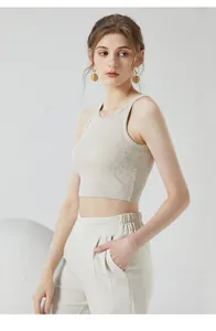 Gros plan sur un débardeur en maille côtelée beige et un pantalon à taille haute