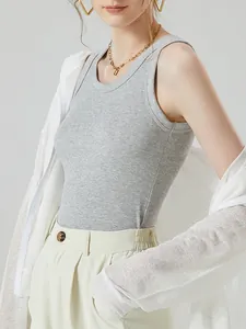 Women's grey ribbed knit tank top paired with white cardigan and high-waist pants