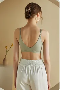 Detail view of sage green sports bra showing V-shaped open back and adjustable straps