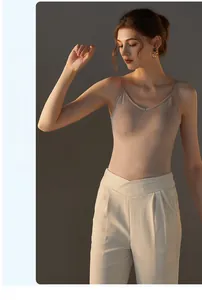 Detailed view of nude modal camisole paired with cream high-waisted wide-leg trousers
