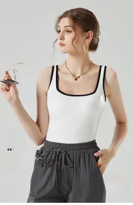 Détail du débardeur blanc avec bordure contrastée noire et tissu en maille élastique