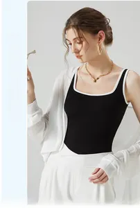 Détail du débardeur noir ajusté avec bordure blanche et d'un cardigan blanc translucide