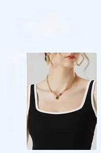 Détail d'un débardeur ajusté à col en U noir avec bordure contrastée blanche et tissu soyeux